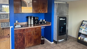 Una kitchenette con cafetera, pileta y dispensador de hielo.