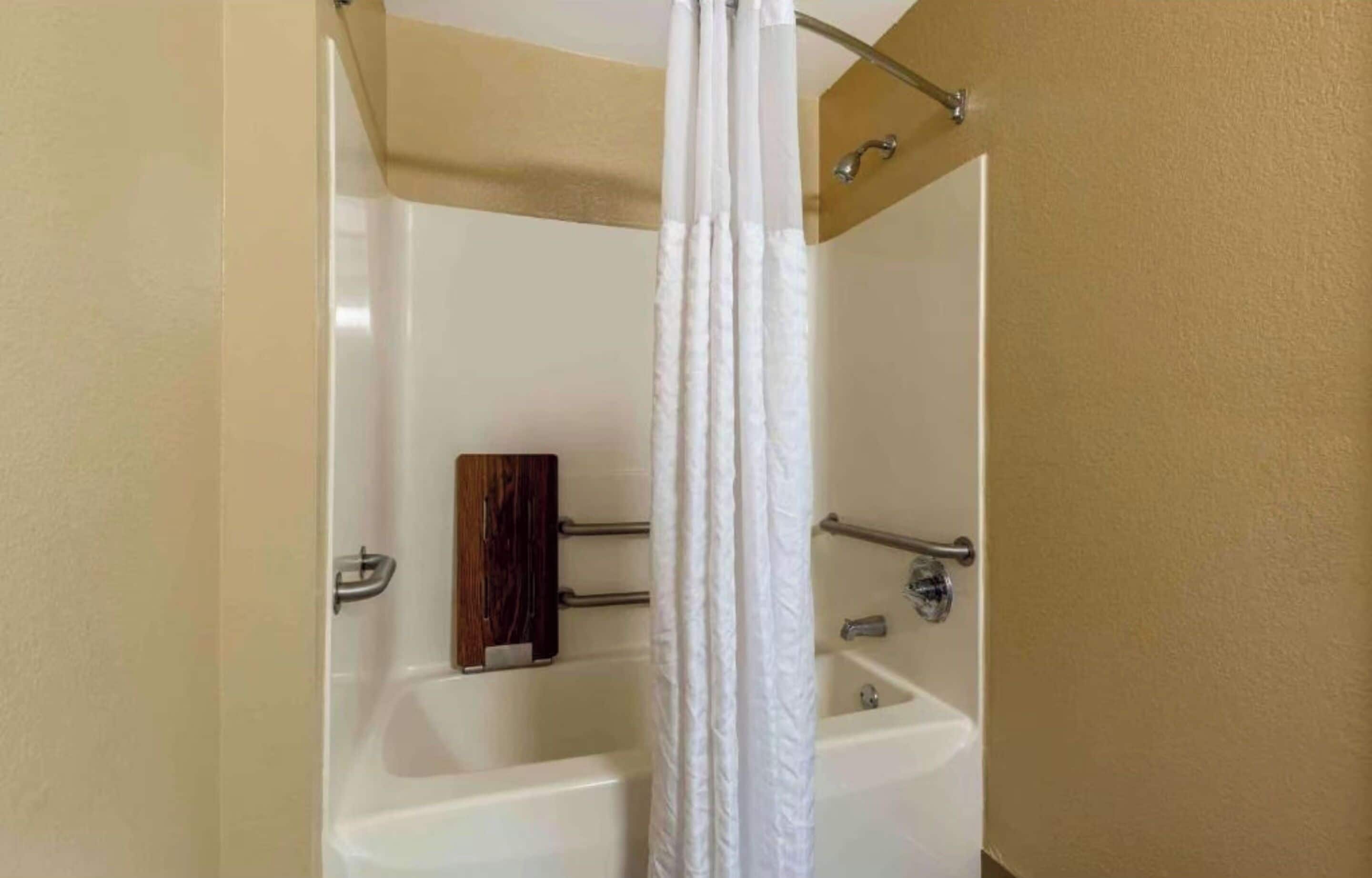 Un baño con bañera, cortina de ducha y paneles de madera.