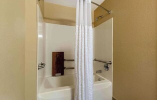 Un baño con bañera, cortina de ducha y paneles de madera.