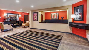 Vestíbulo de hotel con recepción, estación de café y zona de estar.