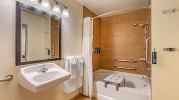 Un baño con lavamanos, espejo, ducha y bañera.