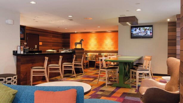 A restaurant with a bar, wooden panel walls, and a TV mounted on the wall.