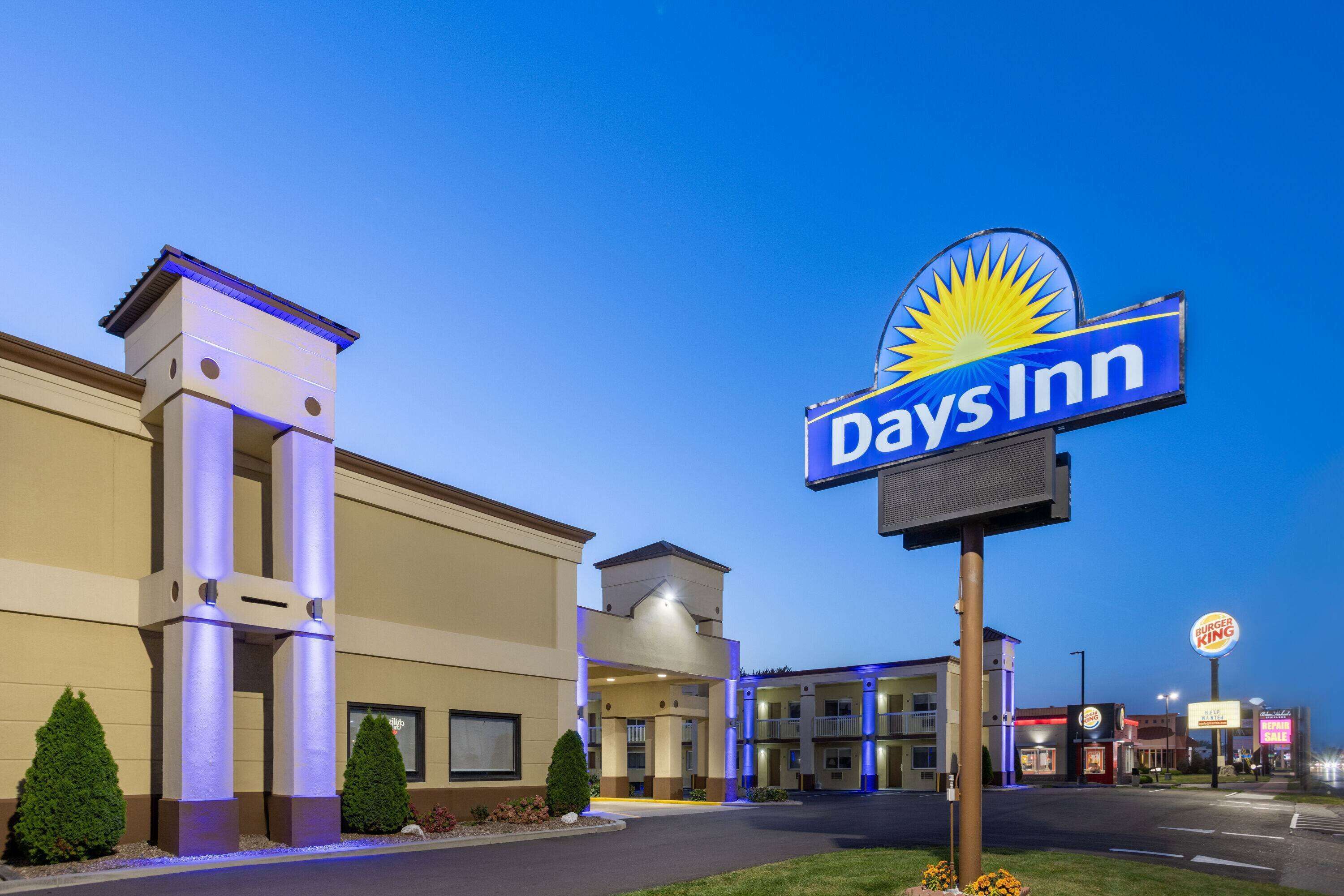 Un hotel Days Inn con un letrero llamativo, un Burger King al otro lado de la calle y un cielo despejado.