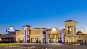 A Days Inn hotel with a modern design, featuring a central entrance, multiple windows, and a parking lot. - Days Inn by Wyndham Tonawanda/Buffalo (Tonawanda)