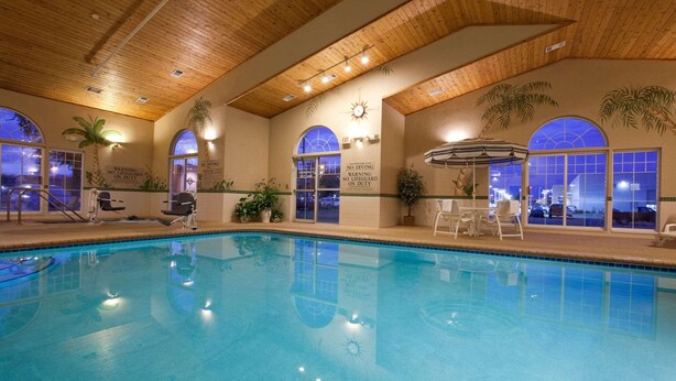 An indoor swimming pool with wooden ceiling, clear glass windows, and a sun clock. - Country Inn & Suites by Radisson, Cedar Falls, IA (Cedar Falls)