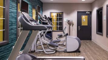 Une salle de remise en forme équipée de tapis de course, d’un vélo elliptique et d’un vélo d’appartement.