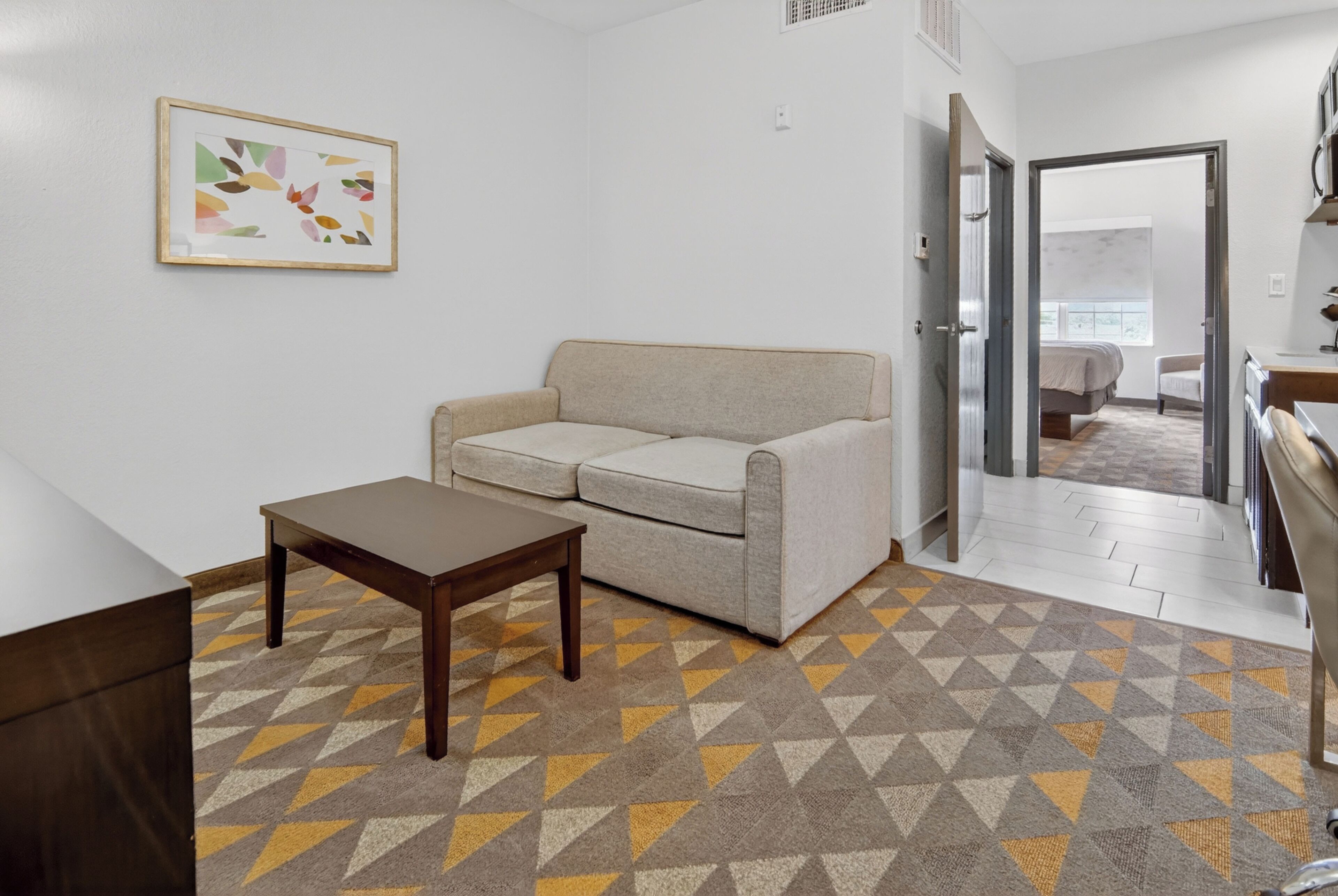 A living room with a sofa, a coffee table, and a patterned rug.