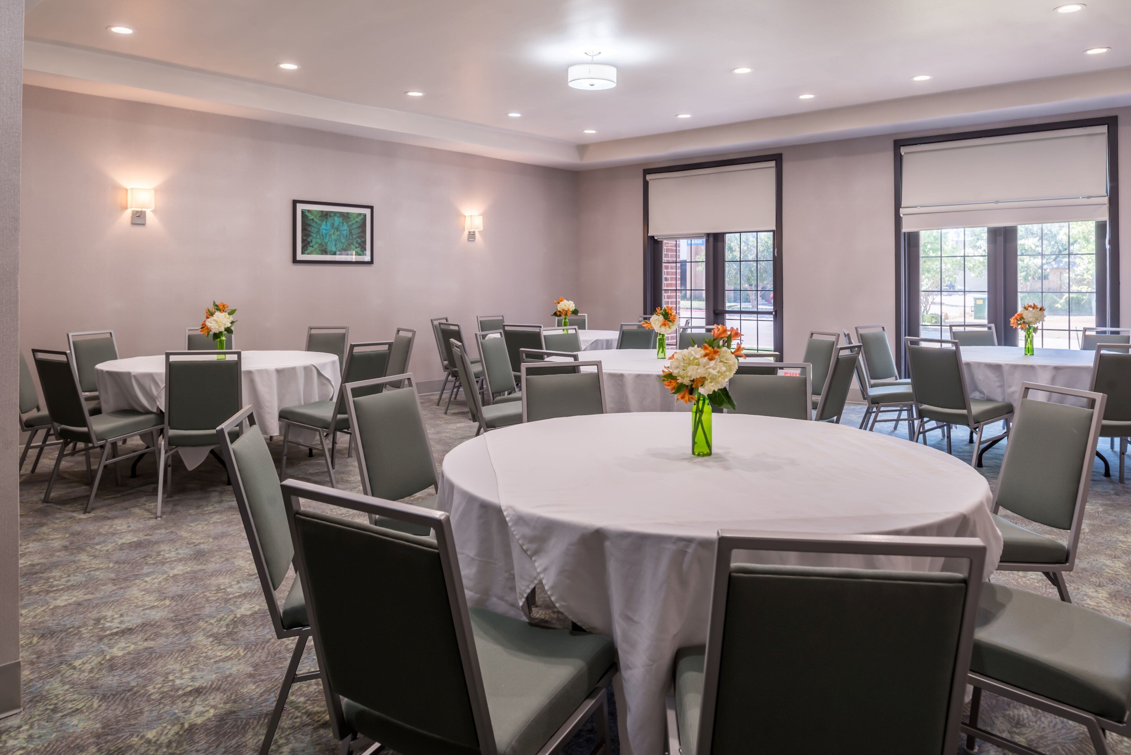 Une salle de conférence dotée de plusieurs tables et chaises, disposées en cercle.