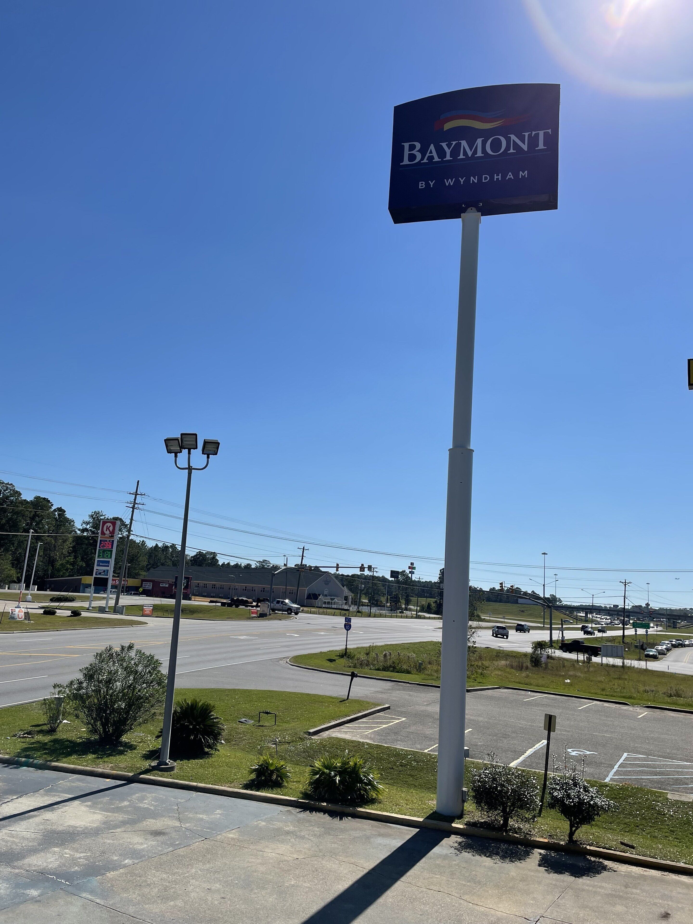 Um estacionamento com placa indicando um hotel Baymont by Wyndham.