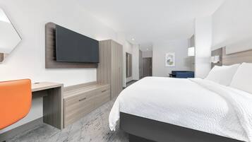 Una habitación de hotel moderna con cama, escritorio y silla.
