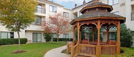 A gazebo in a courtyard surrounded by apartment buildings.