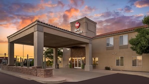 A hotel entrance with a covered outdoor area, a sign reading "Best Western," and a clear sky with clouds. - Best Western Plus Winslow Inn (Winslow)