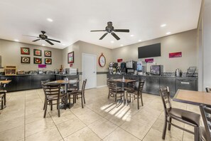 A restaurant with a counter, seating area, ceiling fans, and wall decorations. - Best Western Plus Winslow Inn (Winslow)