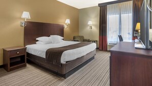 A hotel room with a large bed, two bedside lamps, a nightstand, a desk, and a chair. - Best Western Plus Winslow Inn (Winslow)
