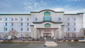 A Wingate by Wyndham hotel with a symmetrical facade, large windows, and a central entrance. - Wingate by Wyndham Tinley Park (Tinley Park)