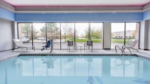 A swimming pool with lounge chairs and a view of the outside. - Wingate by Wyndham Tinley Park (Tinley Park)
