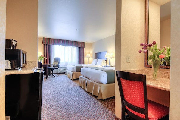 A hotel room with two beds, a desk with a computer, a chair, a mirror, and a vase with flowers. - Holiday Inn Express Temecula by IHG (Temecula)