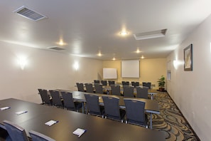 A conference room with a long table, multiple chairs, a whiteboard, and a projector screen. - Holiday Inn Express Temecula by IHG (Temecula)