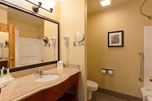 A bathroom with a sink, mirror, hair dryer, and toilet. - Holiday Inn Express Temecula by IHG (Temecula)