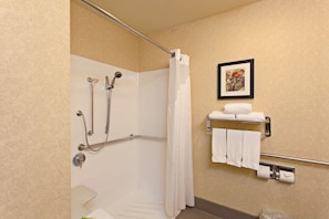 A shower area with a glass door, a hand shower, a glass-enclosed tub, and a towel rack with towels. - Holiday Inn Express Temecula by IHG (Temecula)