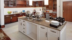 Una cocina moderna con una isla central, armarios empotrados y un espacio para preparar café.