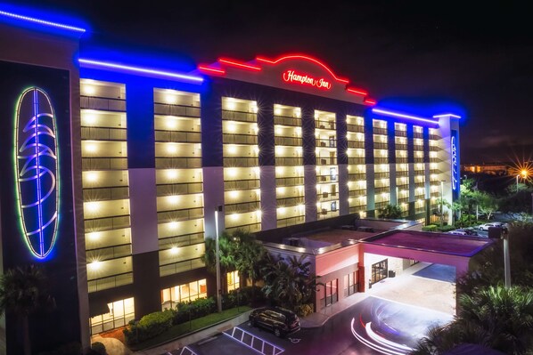 A Hampton Inn hotel with a modern facade, multiple balconies, and a well-lit entrance. - Hampton Inn Cocoa Beach/Cape Canaveral (Cocoa Beach)