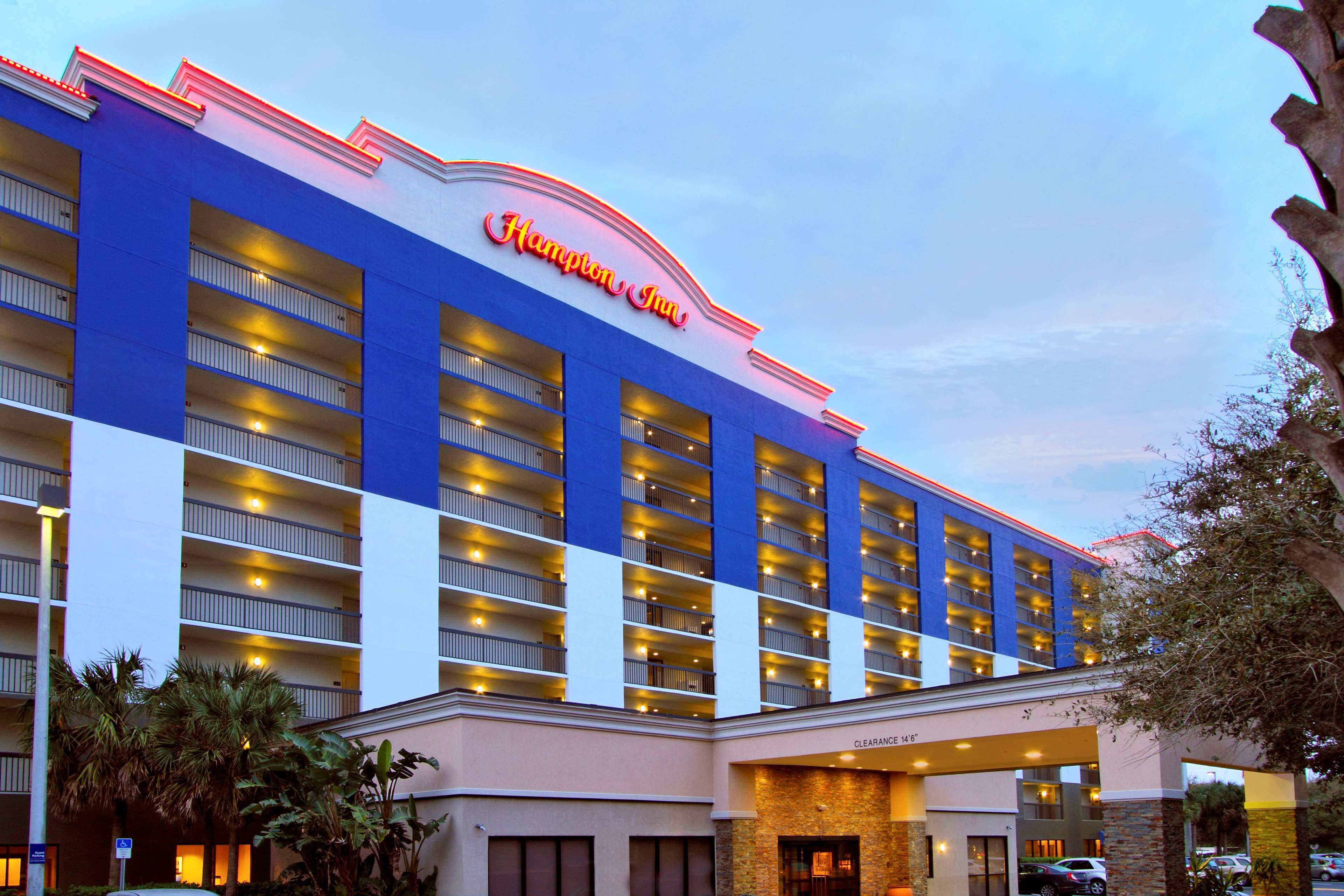 Ein Hampton Inn Hotel mit blauer Fassade, mehreren Balkonen und blauem Himmel.