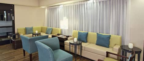 Una sala de estar moderna con un juego de sofá, sillones y una mesa de centro.