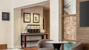 A modern hotel lobby with a coffee station, framed artwork, and comfortable seating. - Hampton Inn Ft. Lauderdale-West/Pembroke Pines (Pembroke Pines)