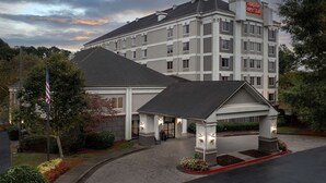 A Hampton Inn & Suites hotel with a covered entrance, landscaped garden, and a flagpole. - Hampton Inn & Suites Alpharetta (Alpharetta)