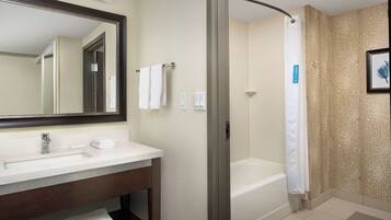 A modern bathroom with a large mirror, a sink, a bathtub, and a shower curtain.