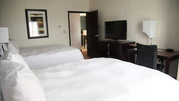 Habitació d'hotel amb dos llits, televisió, escriptori i una cadira.