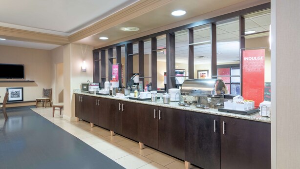 Une cuisine d’hôtel dotée d’un long comptoir, équipée de divers appareils et d’un espace dédié à la préparation du café.