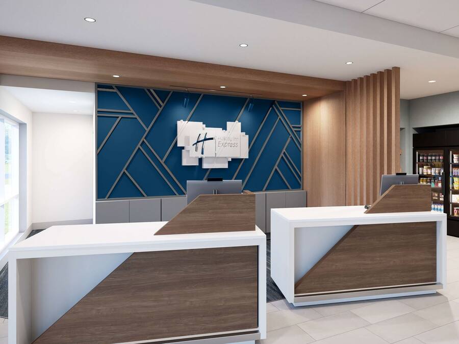 Un área de recepción con diseño moderno, que incluye un mostrador de recepción, un reloj montado en la pared y un revestimiento mural con estampado geométrico.