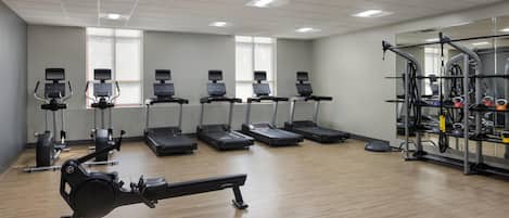 A gym with treadmills, elliptical machines, and a rowing machine.