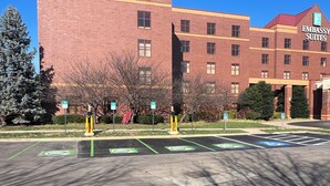 A parking lot with designated spaces for electric vehicles and handicapped parking, in front of a building labeled "Embassy Suites." - Embassy Suites by Hilton Lexington/UK Coldstream (Lexington)