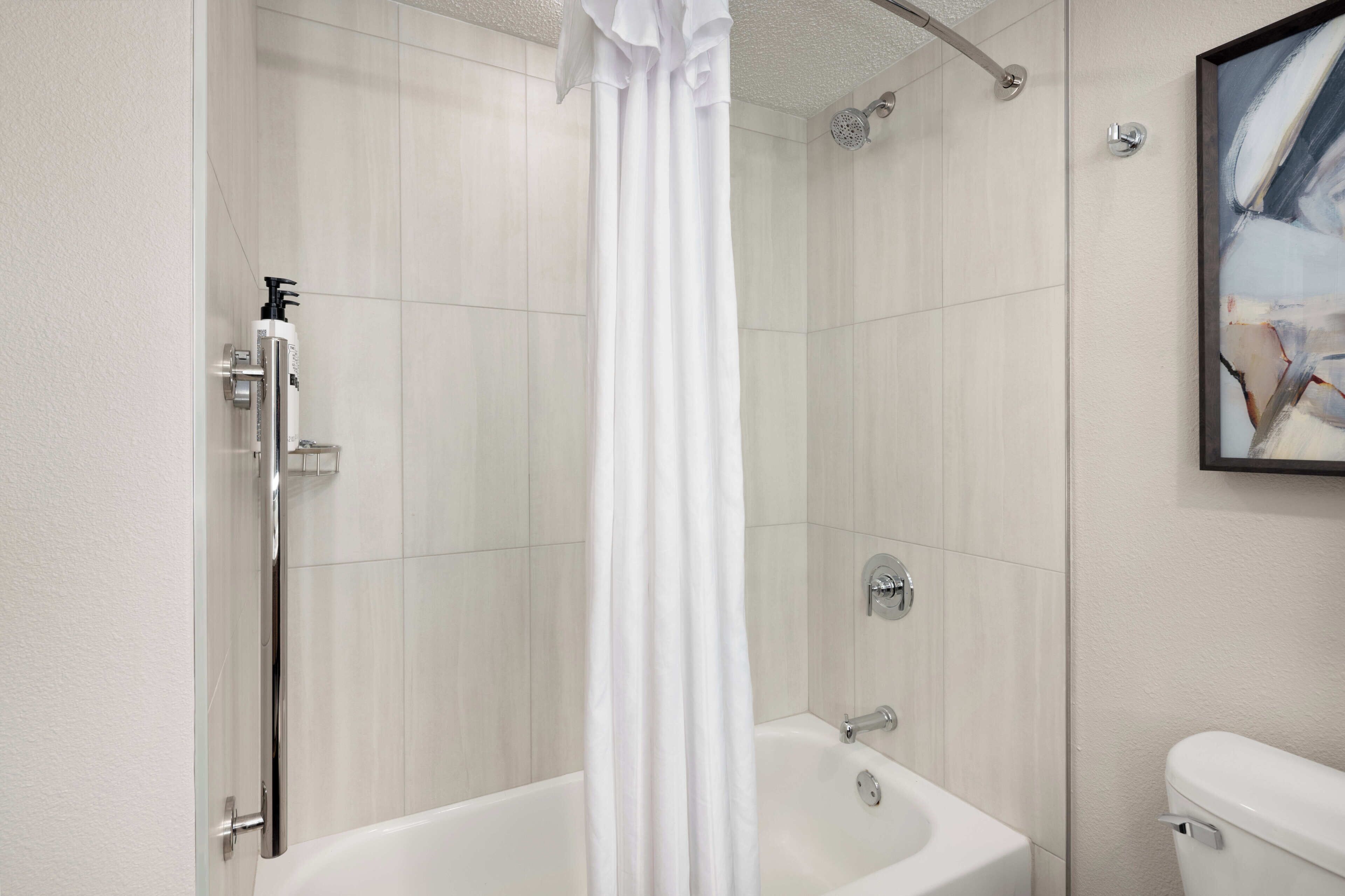 Une salle de bain avec une douche, une baignoire et des toilettes.