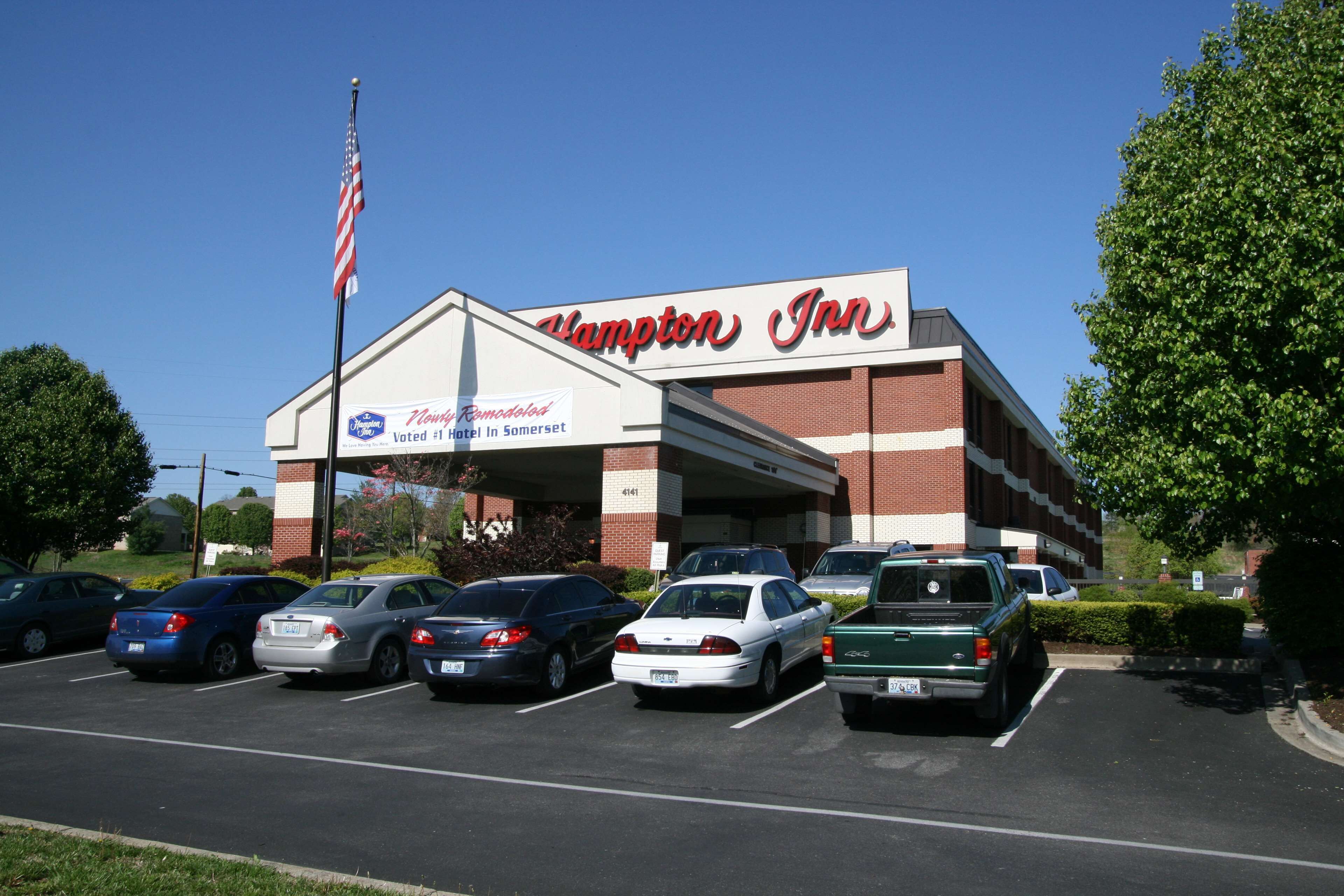 Un hôtel Hampton Inn avec un parking rempli de voitures.