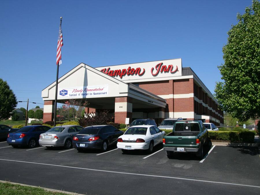 Un hôtel Hampton Inn avec un parking rempli de voitures.
