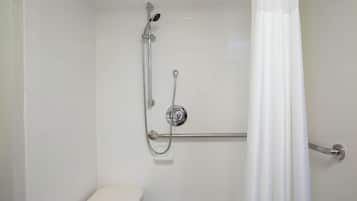 Een douche met een handdouche, een doucheaanslag voor de hand en een handgreep.