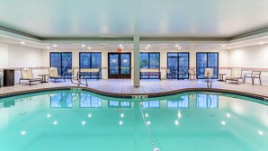 An indoor swimming pool with clear water, benches, and a lifeguard chair. - Hampton Inn Boston/Peabody (Peabody)