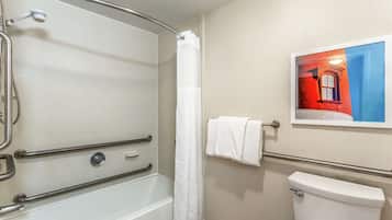 A bathroom with a bathtub, shower, and toilet.