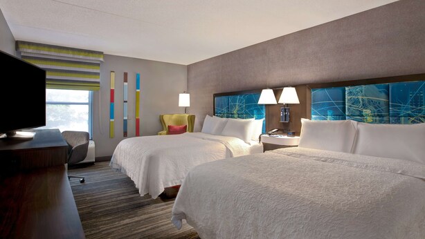 A hotel room with two beds, a desk, a TV, and a window with blinds. - Hampton Inn Olive Branch (Olive Branch)