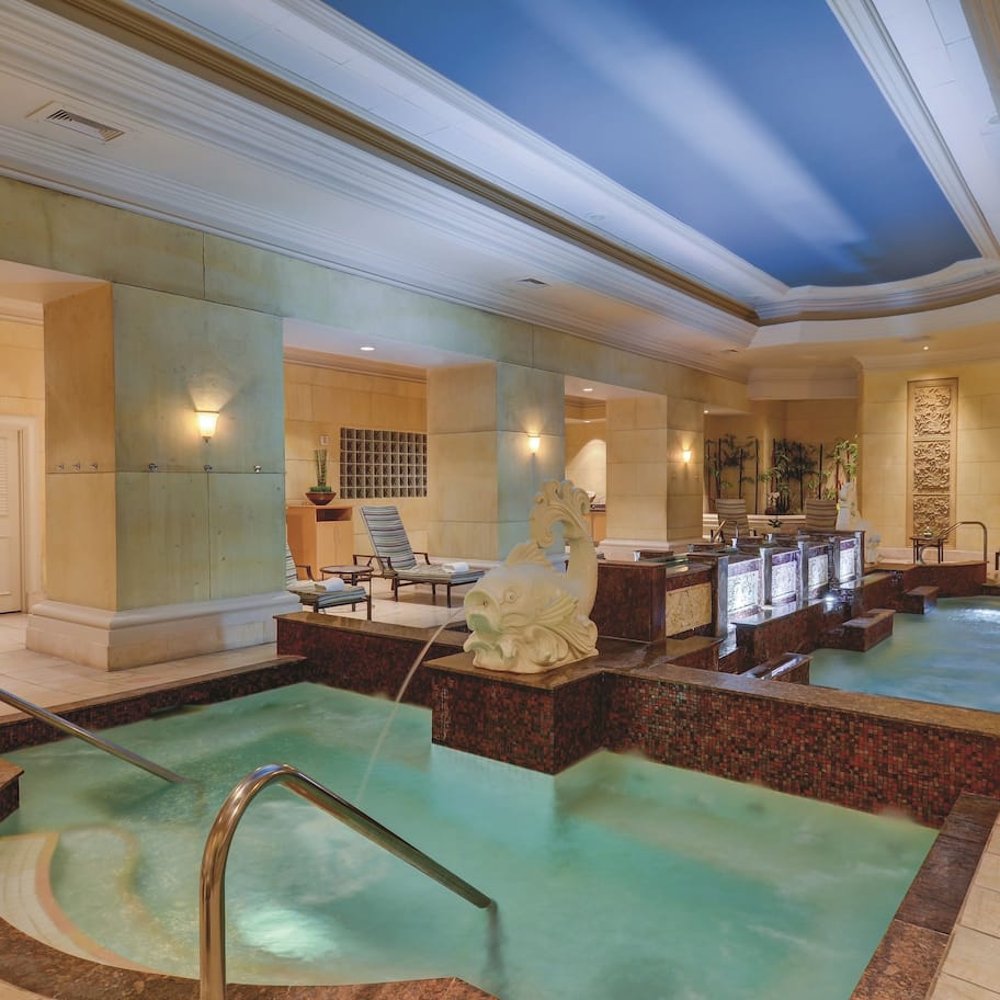 A spa area with multiple hot tubs, seating areas, and a reception desk.