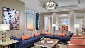 A modern living room with a large sectional sofa, a coffee table, and a dining area with a table and chairs.