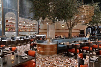 A hotel reception area with a long counter, ornate ceiling, and a large screen displaying a waterfall. at Mandalay Bay Resort And Casino