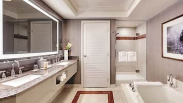 Een moderne badkamer met een grote spiegel, twee wastafels, een bad en een douche.
