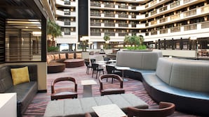 A spacious indoor lobby with multiple seating areas, including sofas, chairs, and a central coffee table. - Embassy Suites by Hilton Las Vegas (Las Vegas)