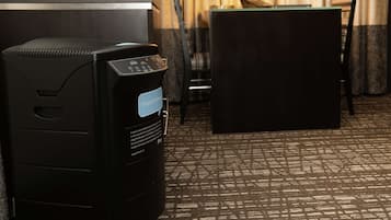 Una habitación de hotel con un escritorio grande negro, una computadora y una lámpara.
