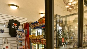 Interior de una tienda con diversos productos en estantes y un carrito de compras lleno de aperitivos.